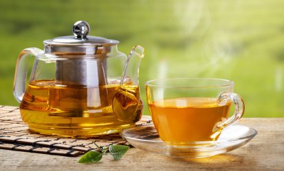 Warm,Cup,Of,Tea,With,Teapot,,Green,Tea,Leaves,On